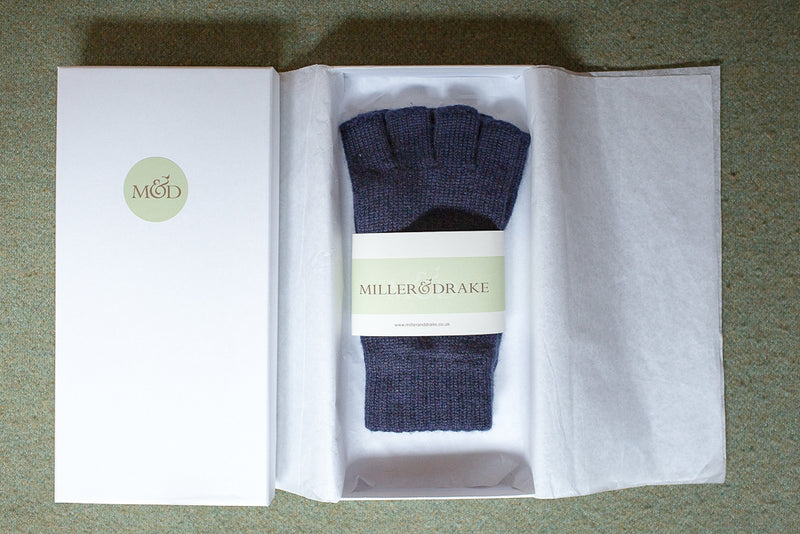 100% cashmere navy blue fingerless gloves wrapped in tissue paper in a luxury white gift box