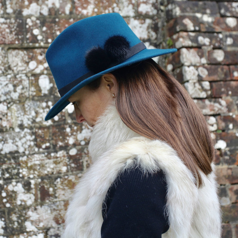 teal wool felt fedora with black band and two black fur pom poms